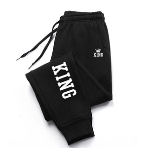 Dettaglio dei pantaloni sportivi neri da uomo con stampa corona King e polsini a coste