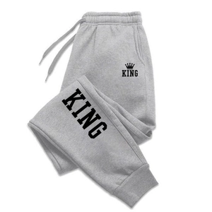 Dettaglio dei pantaloni jogger grigi con stampa KING e vita elastica con coulisse