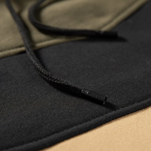 Close-up of drawstring detail on a tricolor patchwork hoodie with premium matte metal tips