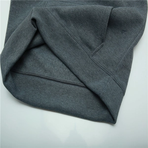 Macro shot of dark grey thick fleece lining and durable stitching on the sweatshirt hem
