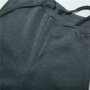 Detailed view of dark grey tracksuit bottoms featuring an elastic waist and black drawstrings
