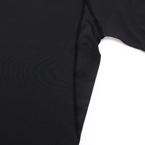 Flatlock seam detail on black compression gym shirt showing sweat-wicking fabric