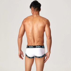 Macro detail of men's white ribbed briefs featuring a black Caution lettered waistband