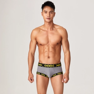 Detail of grey men's trunks featuring a U-convex pouch and yellow Caution print branding