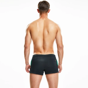 Rear view detail of black swim trunks with green side stripes and square back pocket