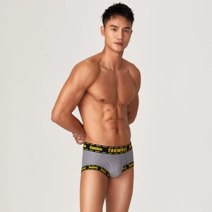 Detail of grey ribbed men's boxer briefs with yellow Caution print elastic waistband