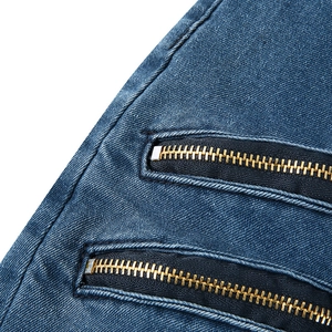 Gros plan sur un denim usé avec fermetures éclair métalliques et détails de sergé