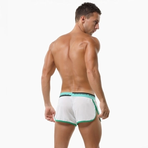 Close-up of men's low-waist white knit trunks with green trim and side slit detail