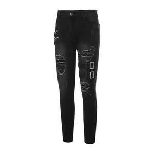 Détail d'un jean slim noir vieilli avec fermetures éclair métalliques et sangles punk biker