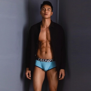 Detail of light blue modal boxer briefs with black TAUWE logo elastic waistband on male model