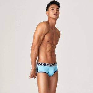Detail of bright blue men's modal boxer briefs with elastic logo waistband on model