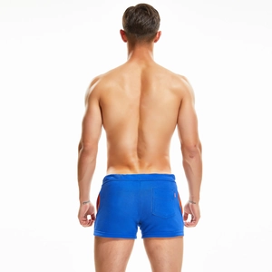 Detail view of royal blue men's sports shorts with orange side stripes and back pocket
