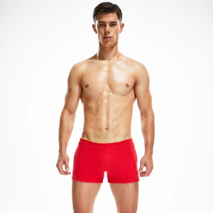 Close-up of red low-rise men's trunk shorts with fine yellow waist trim and polished texture