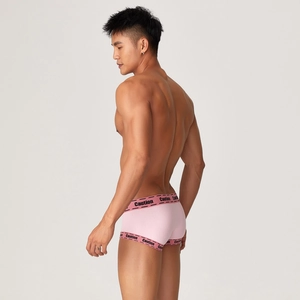Detail of pink men's sports boxer briefs featuring black Caution logo elastic waistband