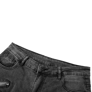 Détail du jean style motard avec fermeture éclair décorative et bouton métallique