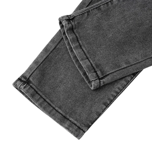 Détail de l'ourlet à double couture sur un jean en denim noir délavé avec effet usé
