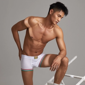 Dettaglio di boxer da uomo bianchi con elastico a righe e etichetta del logo