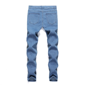 Detail view of men's slim fit light blue jeans with back pockets and washed denim texture