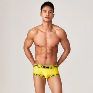 Detail of yellow ribbed cotton men's boxer briefs with black caution text and logo print