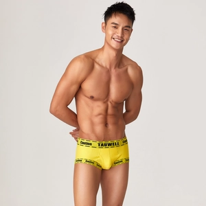 Detailed close-up of yellow sports boxer briefs with black Caution printed waistband