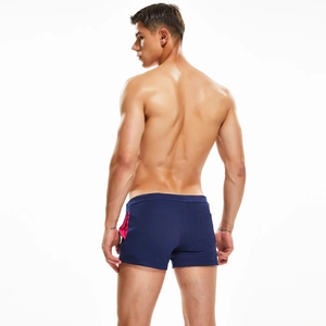 Macro detail of the back pocket and pink contrast trim on men's navy blue gym shorts