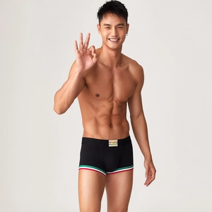 Dettaglio dei boxer da uomo neri con elastico tricolore e logo giallo centrale