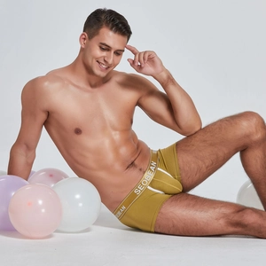 Detail view of olive green men's boxer briefs with elastic branded waistband on a model