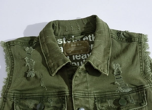 Detail of army green denim vest showing distressed texture and leather brand label