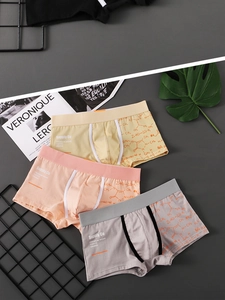 Flat lay of three printed men's boxer briefs in yellow, orange, and grey with elastic waist