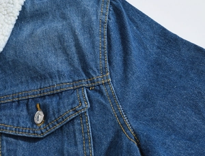 Detail of blue denim jacket showing faux shearling collar and contrast stitching