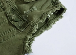 Detailed close-up of army green denim vest showing distressed fabric and metal pocket button