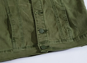 Detailed close-up of army green denim vest with distressed holes and matte metal buttons