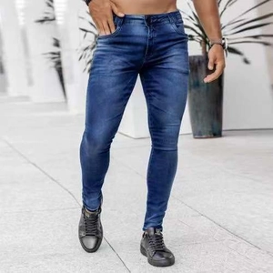 Detail view of men's slim fit blue jeans showing whiskering and distressed thigh patterns
