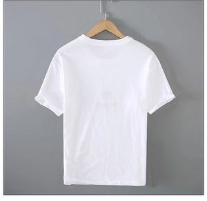 Détail d'un t-shirt blanc en lin avec col rond suspendu sur un cintre en bois