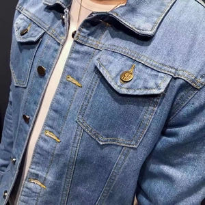 Detailed close-up of light blue denim jacket with yellow topstitching and metal buttons