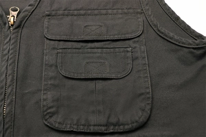 Dettaglio del gilet cargo con tasche multiple, cuciture resistenti e zip in rame vintage