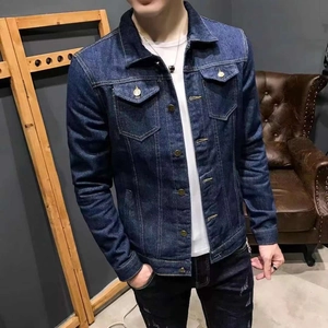 Detail of classic metal button closure and chest pockets on blue denim jacket