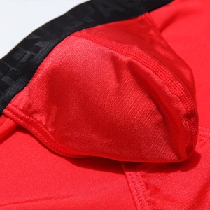 Macro shot of men's red ice silk briefs showing U-convex pouch and breathable ribbed texture