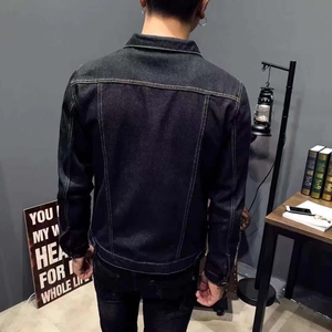 Detail of dark wash denim jacket featuring contrast stitching on back and classic collar