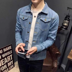 Detail shot of light blue denim jacket with metallic buttons and classic chest pockets