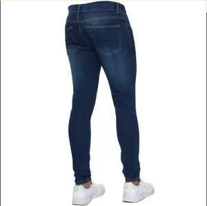 Detail view of men's slim fit jeans in dark blue with orange stitching and wash effects