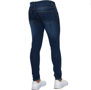 Detail view of the back pocket with visible contrast stitching on dark blue skinny jeans