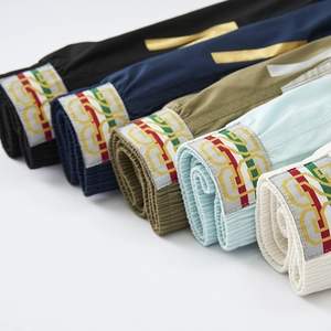 Detail of colorful men's athletic shorts featuring elastic waistbands and embroidery patches