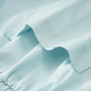 Detailed macro view of light blue shorts showing twill texture and stitching on the pocket