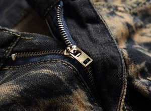 Close-up of vintage metal zipper and distressed denim texture on men's jeans