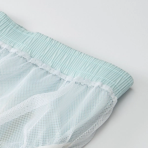 Detail view of elastic waistband and breathable white mesh lining on casual sports shorts