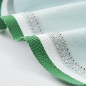 Detailed macro view of mint green fabric with white webbing and intricate wave stitching