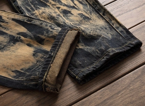 Macro shot of rolled hem on men's vintage acid wash denim with gold contrast stitching