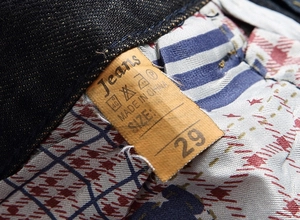Close-up of retro denim jeans inner waistband featuring wash label and vintage lining