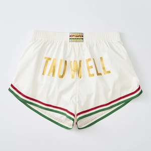 Detail of white athletic shorts with golden TAUWELL print and striped elastic waistband